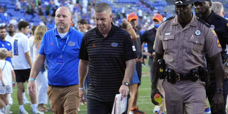 Florida head coach Billy Napier, center, walks off the field after his team was defeated by Miami, 41-17, in an NCAA college football game, Saturday, Aug. 31, 2024, in Gainesville, Fla. (AP Photo/John Raoux)