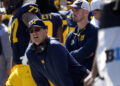 FILE - Michigan head coach Jim Harbaugh, front left, watches against Rutgers as analytics assistant Connor Stalions, right, looks on during an NCAA college football game in Ann Arbor, Mich., Sept. 23, 2023. A Michigan judge who champions peacemaking principles in court will preside over a hearing on Friday that will determine whether Jim Harbaugh can coach and close the regular season on the field with the third-ranked Wolverines. Attorneys for Harbaugh and the university are asking Judge Timothy P. Connors to at least temporarily lift the Big Ten’s penalty against him for a sign-stealing scheme. (AP Photo/Paul Sancya, FILE)