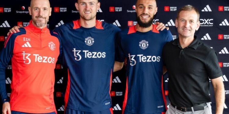 Matthijs de Ligt and Noussair Mazraoui of Manchester United pose with manager Erik ten Hag and Sporting Director Dan Ashworth after signing for the club, August 13, 2024