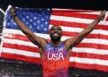 Noah Lyles holds an American flag