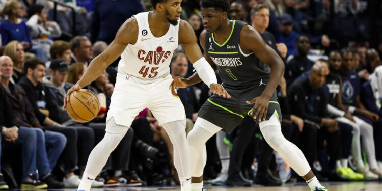 Donovan Mitchell #45 of the Cleveland Cavaliers dribbles the ball while Anthony Edwards #1 of the Minnesota Timberwolves defends