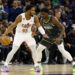 Donovan Mitchell #45 of the Cleveland Cavaliers dribbles the ball while Anthony Edwards #1 of the Minnesota Timberwolves defends