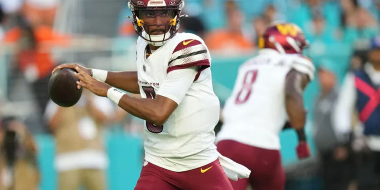 Aug 17, 2024; Miami Gardens, Florida, USA; Washington Commanders quarterback Jayden Daniels (5) drops back to pass against the Miami Dolphins during the first quarter at Hard Rock Stadium. Mandatory Credit: Jim Rassol-USA TODAY Sports