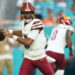 Aug 17, 2024; Miami Gardens, Florida, USA; Washington Commanders quarterback Jayden Daniels (5) drops back to pass against the Miami Dolphins during the first quarter at Hard Rock Stadium. Mandatory Credit: Jim Rassol-USA TODAY Sports