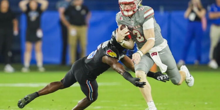 Sep 13, 2024; Kansas City, Kansas, USA; UNLV Rebels quarterback Matthew Sluka (3) runs the ball against Kansas Jayhawks safety O.J. Burroughs (5) during the second half at Children's Mercy Park. Mandatory Credit: Jay Biggerstaff-Imagn Images