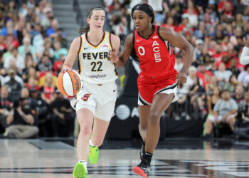 LAS VEGAS, NEVADA - JULY 02: Caitlin Clark #22 of the Indiana Fever brings the ball up the court against Jackie Young #0 of the Las Vegas Aces in the second quarter of their game at T-Mobile Arena on July 02, 2024 in Las Vegas, Nevada. The Aces defeated the Fever 88-69. NOTE TO USER: User expressly acknowledges and agrees that, by downloading and or using this photograph, User is consenting to the terms and conditions of the Getty Images License Agreement. (Photo by Ethan Miller/Getty Images)