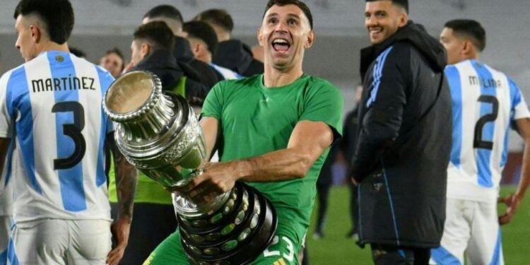 Argentina goalkeeper Emiliano Martinez holds a replica Copa America trophy against his crotch