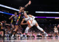 PHOENIX, ARIZONA - AUGUST 28: Kayla McBride #21 of the Minnesota Lynx drives into Natasha Cloud #0 of the Phoenix Mercury during the first half at Footprint Center on August 28, 2024 in Phoenix, Arizona.The Lynx defeated the Mercury 89-76.  NOTE TO USER: User expressly acknowledges and agrees that, by downloading and or using this photograph, User is consenting to the terms and conditions of the Getty Images License Agreement.  (Photo by Chris Coduto/Getty Images)