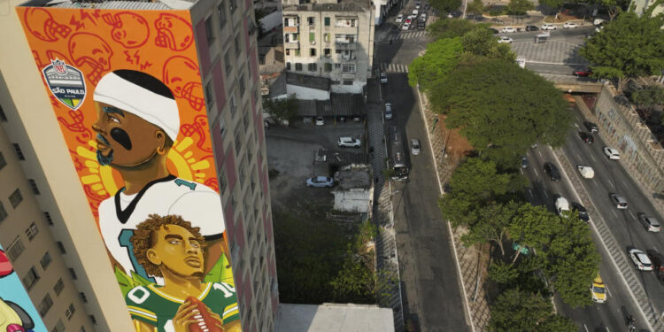 A mural created by artist Crica featuring Philadelphia Eagles quarterback Jalen Hurts and Green Bay Packers quarterback Jordan Love adorns an apartment building in downtown Sao Paulo. (AP Photo/Andre Penner)