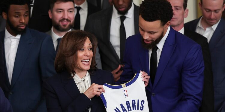 Golden State Warriors star Steph Curry presents U.S. Vice President Kamala Harris with a jersey.