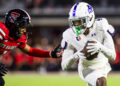 LUBBOCK, TEXAS - AUGUST 31: J.J. Henry #4 of the Abilene Christian Wildcats runs with the ball against A.J. McCarty #1 of the Texas Tech Red Raiders during the second half of the game at Jones AT&T Stadium on August 31, 2024 in Lubbock, Texas.  (Photo by John E. Moore III/Getty Images)