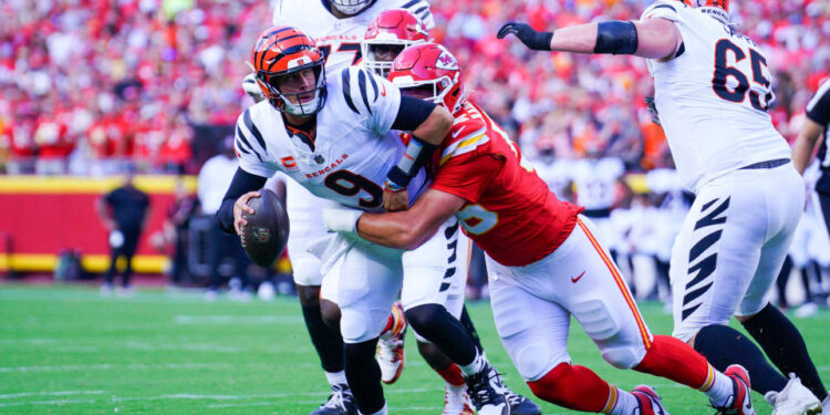 Sep 15, 2024; Kansas City, Missouri, USA; Cincinnati Bengals quarterback Joe Burrow (9) is sacked by Kansas City Chiefs defensive end George Karlaftis (56) during the first half at GEHA Field at Arrowhead Stadium. Mandatory Credit: Denny Medley-Imagn Images