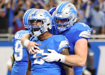 DETROIT, MICHIGAN - SEPTEMBER 08: David Montgomery #5 of the Detroit Lions celebrates with Frank Ragnow #77 after scoring a touchdown in overtime to beat the Los Angeles Rams 26-20 at Ford Field on September 08, 2024 in Detroit, Michigan. (Photo by Gregory Shamus/Getty Images)