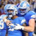 DETROIT, MICHIGAN - SEPTEMBER 08: David Montgomery #5 of the Detroit Lions celebrates with Frank Ragnow #77 after scoring a touchdown in overtime to beat the Los Angeles Rams 26-20 at Ford Field on September 08, 2024 in Detroit, Michigan. (Photo by Gregory Shamus/Getty Images)