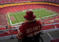 A fan watches warmups at Arrowhead Stadium ahead of the game-delaying storm. (AP Photo/Charlie Riedel)