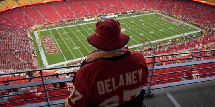 A fan watches warmups at Arrowhead Stadium ahead of the game-delaying storm. (AP Photo/Charlie Riedel)