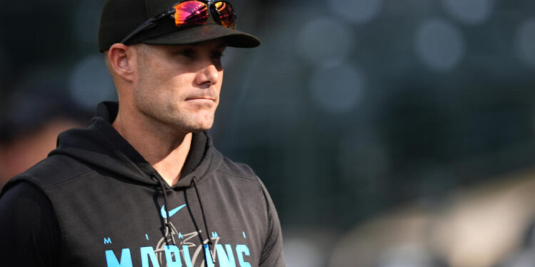 Miami Marlins manager Skip Schumaker (45) warms up before a baseball game Wednesday, Aug. 28, 2024, in Denver. (AP Photo/David Zalubowski)