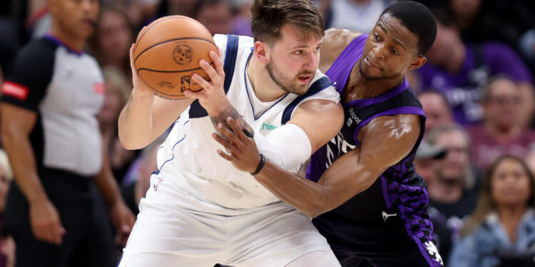 SACRAMENTO, CALIFORNIA - MARCH 26: De'Aaron Fox #5 of the Sacramento Kings guards Luka Doncic #77 of the Dallas Mavericks in the first half at Golden 1 Center on March 26, 2024 in Sacramento, California. NOTE TO USER: User expressly acknowledges and agrees that, by downloading and or using this photograph, User is consenting to the terms and conditions of the Getty Images License Agreement.  (Photo by Ezra Shaw/Getty Images)