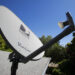 FILE - In this May 6, 2010 file photo, a DirecTV satellite dish is attached to a roof at a home in Palo Alto, Calif. The government is taking the nation's biggest satellite TV provider to court, accusing DirecTV of misleading millions of consumers about the cost of its programming. The Federal Trade Commission said Wednesday that its complaint charges DirecTV Inc. with deceptively advertising a discounted 12-month programming package. Consumers weren't clearly told that the package requires a two-year contract, the commission said. (AP Photo/Paul Sakuma, File)