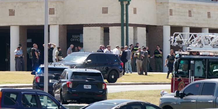 Law enforcement officers work at the scene of a shooting at Apalachee High School