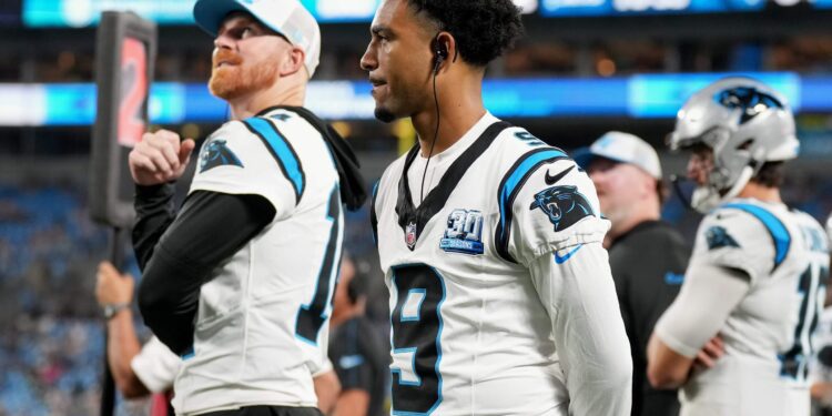 Andy Dalton and Bryce Young of the Carolina Panthers watch during the second half of their preseason game against the New York Jets at Bank of America Stadium on August 17, 2024 in Charlotte, North Carolina.