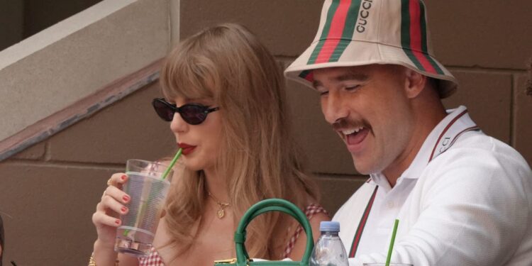 Taylor Swift takes a sip of her drink while seated next to Kansas City Chiefs tight end Travis Kelce on the final day of the U.S. Open tennis tournament, Sept. 8, 2024.