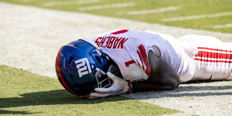 Malik Nabers laying down with hands on head