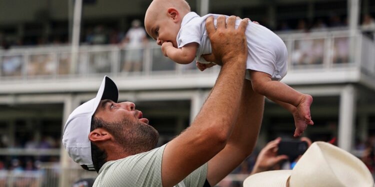 Scottie Scheffler holds son