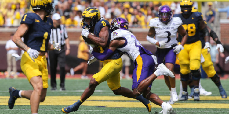 ANN ARBOR, MI - SEPTEMBER 02:  Michigan Wolverines wide receiver Cornelius Johnson (6) runs with the ball after catching a pass while trying to avoid being tackled by East Carolina Pirates defensive back Shavon Revel (28) during the third quarter of a non-conference college football game between the East Carolina Pirates and the Michigan Wolverines on September 2, 2023 at Michigan Stadium in Ann Arbor, Michigan.  (Photo by Scott W. Grau/Icon Sportswire via Getty Images)