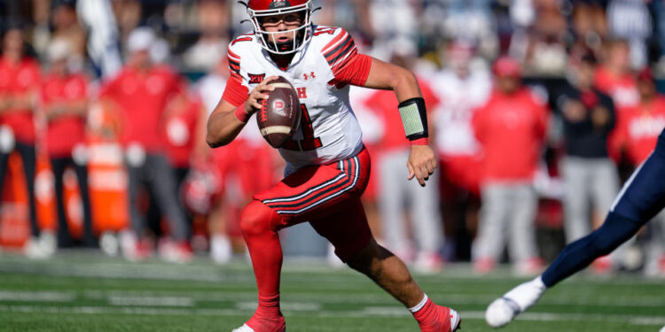 Sep 14, 2024; Logan, Utah, USA;  Utah Utes quarterback Isaac Wilson (11) runs with the ball against the Utah State Aggies at Merlin Olsen Field at Maverik Stadium. Mandatory Credit: Jamie Sabau-Imagn Images