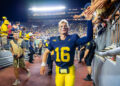 ANN ARBOR, MICHIGAN - AUGUST 31: Davis Warren #16 of the Michigan Wolverines interacts with fans as he walks off the field after a college football game against the Fresno St. Bulldogs at Michigan Stadium on August 31, 2024 in Ann Arbor, Michigan. The Michigan Wolverines won the game 30-10. (Photo by Aaron J. Thornton/Getty Images)