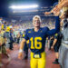 ANN ARBOR, MICHIGAN - AUGUST 31: Davis Warren #16 of the Michigan Wolverines interacts with fans as he walks off the field after a college football game against the Fresno St. Bulldogs at Michigan Stadium on August 31, 2024 in Ann Arbor, Michigan. The Michigan Wolverines won the game 30-10. (Photo by Aaron J. Thornton/Getty Images)