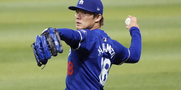 Injured Los Angeles Dodgers starting pitcher Yoshinobu Yamamoto, of Japan, warms up prior to a baseball game against the Arizona Diamondbacks, Sunday, Sept. 1, 2024, in Phoenix. (AP Photo/Ross D. Franklin)