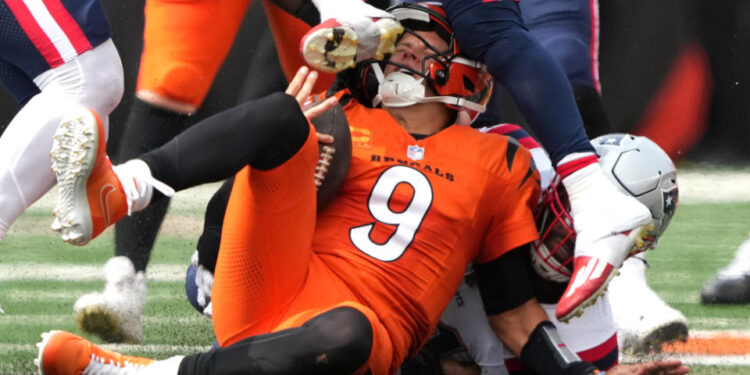 CINCINNATI, OHIO - SEPTEMBER 08: Joe Burrow #9 of the Cincinnati Bengals is hit in the helmet by the cleat of Jabrill Peppers #5 of the New England Patriots in the second quarter of the game at Paycor Stadium on September 08, 2024 in Cincinnati, Ohio. (Photo by Dylan Buell/Getty Images)