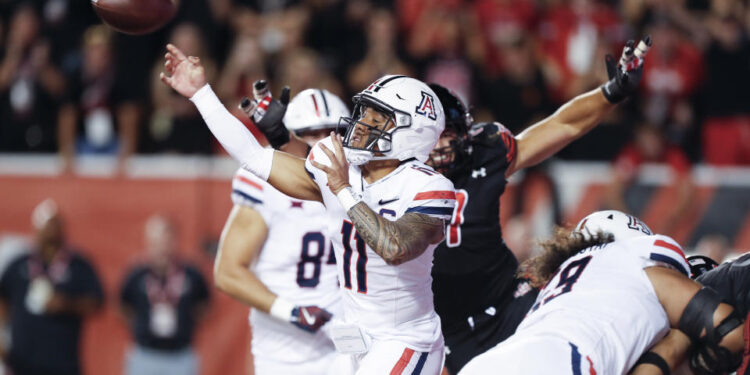 SALT LAKE CITY, UT - SEPTEMBER 28: Noah Fifita #11 of the Arizona Wildcats throws under pressure from the Utah Utes during the first half of their game at Rice Eccles Stadium on September 28, 2024 in Salt Lake City, Utah. (Photo by Chris Gardner/Getty Images)