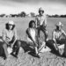 Etchohuaquila, Sonora, Mexico - VALENZUELA FAMILY - Left to right, Daniel, Avelino, Francisco and Manuel Valenzuela, visit the field where they all learned to play baseball, April 27, 1981. The small town of Etchohuaquila, in the municipality of Navojoa in the state of Sonora, Mexico, is seen in the background, as the brothers sit on the log that serves as the team bench. Photo Credit: Jose Galvez / Los Angeles Times