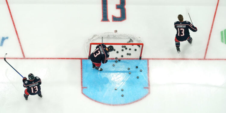 COLUMBUS, OHIO - OCTOBER 15: Columbus Blue Jackets players warm up before the game against the Florida Panthers at Nationwide Arena on October 15, 2024 in Columbus, Ohio. Players from both teams are wearing #13 in warm up jerseys in remembrance of Blue Jackets player Johnny Gaudreau, who along with his brother, was killed by a driver while biking in Salem County, New Jersey in August.  (Photo by Jason Mowry/Getty Images)