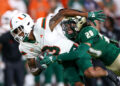 Sep 21, 2024; Tampa, Florida, USA; Miami Hurricanes wide receiver Jacolby George (3) is tackled by South Florida Bulls cornerback Brent Austin (20) in the first quarter at Raymond James Stadium. Mandatory Credit: Nathan Ray Seebeck-Imagn Images