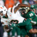 Sep 21, 2024; Tampa, Florida, USA; Miami Hurricanes wide receiver Jacolby George (3) is tackled by South Florida Bulls cornerback Brent Austin (20) in the first quarter at Raymond James Stadium. Mandatory Credit: Nathan Ray Seebeck-Imagn Images