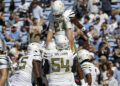 Georgia Tech running back Chad Alexander (27) is hoisted up by his teammates after he scored a touchdown during the first half of an NCAA college football game against North Carolina, Saturday, Oct. 12, 2024, in Chapel Hill, N.C. (AP Photo/Chris Seward)