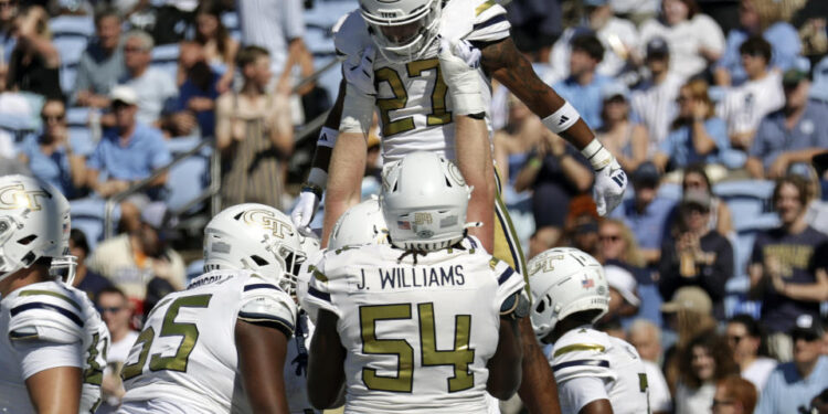 Georgia Tech running back Chad Alexander (27) is hoisted up by his teammates after he scored a touchdown during the first half of an NCAA college football game against North Carolina, Saturday, Oct. 12, 2024, in Chapel Hill, N.C. (AP Photo/Chris Seward)