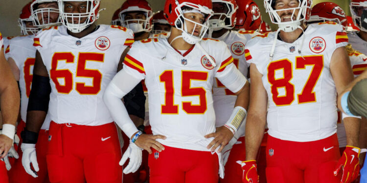 INGLEWOOD, CA - SEPTEMBER 29, 2024: Kansas City Chiefs tight end Travis Kelce (87), right, grins next to Kansas City Chiefs quarterback Patrick Mahomes (15) and Kansas City Chiefs guard Trey Smith (65) before they run onto the field to face the Chargers at the So-Fi Stadium on September 29, 2024 in Inglewood, California. (Gina Ferazzi / Los Angeles Times via Getty Images)