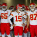 INGLEWOOD, CA - SEPTEMBER 29, 2024: Kansas City Chiefs tight end Travis Kelce (87), right, grins next to Kansas City Chiefs quarterback Patrick Mahomes (15) and Kansas City Chiefs guard Trey Smith (65) before they run onto the field to face the Chargers at the So-Fi Stadium on September 29, 2024 in Inglewood, California. (Gina Ferazzi / Los Angeles Times via Getty Images)