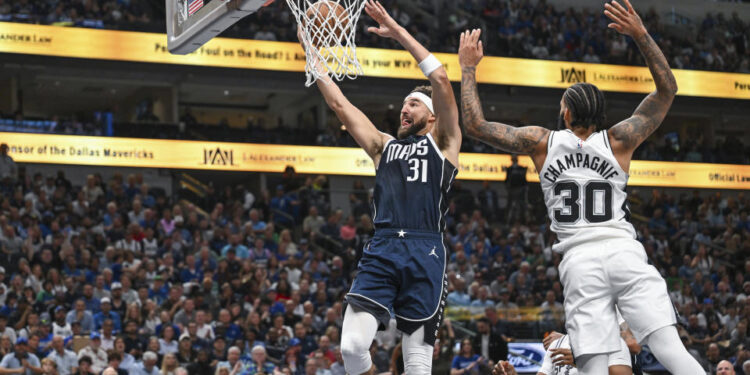 Dallas Mavericks' guard Klay Thompson (31) goes for a layup as he is guarded by San Antonio Spurs' forward Julian Champagnie (30) during the second half of an NBA basketball game, Thursday, Oct. 24, 2024, in Dallas, Texas. (AP Photo/Albert Pena)