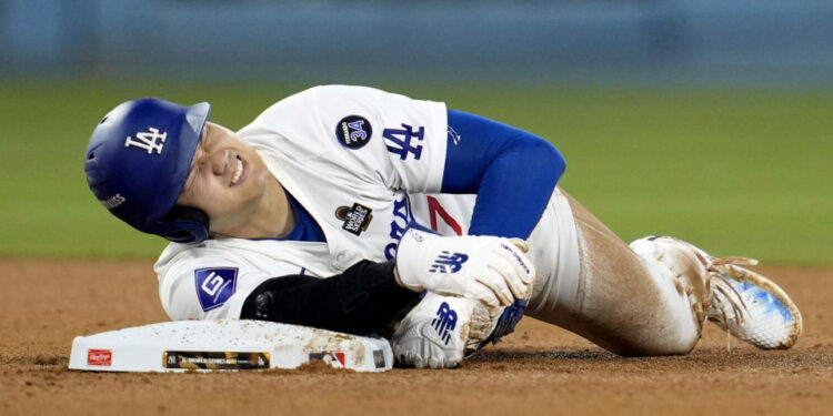 Los Angeles Dodgers' Shohei Ohtani holds his arm after being injured while trying to steal second base during the seventh inning in Game 2 of the baseball World Series against the New York Yankees, Saturday, Oct. 26, 2024, in Los Angeles. (AP Photo/Godofredo A. Vásquez)