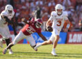 DALLAS, TEXAS - OCTOBER 12: Quinn Ewers #3 of the Texas Longhorns runs the ball avoiding a tackle by R Mason Thomas #32 of the Oklahoma Sooners during the third quarter at Cotton Bowl Stadium on October 12, 2024 in Dallas, Texas. (Photo by Sam Hodde/Getty Images)