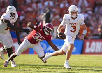 DALLAS, TEXAS - OCTOBER 12: Quinn Ewers #3 of the Texas Longhorns runs the ball avoiding a tackle by R Mason Thomas #32 of the Oklahoma Sooners during the third quarter at Cotton Bowl Stadium on October 12, 2024 in Dallas, Texas. (Photo by Sam Hodde/Getty Images)