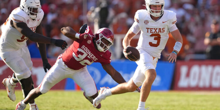 DALLAS, TEXAS - OCTOBER 12: Quinn Ewers #3 of the Texas Longhorns runs the ball avoiding a tackle by R Mason Thomas #32 of the Oklahoma Sooners during the third quarter at Cotton Bowl Stadium on October 12, 2024 in Dallas, Texas. (Photo by Sam Hodde/Getty Images)