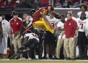 USC receiver Kyle Ford leaps over Rutgers defensive back Flip Dixon during the Trojans' win Friday night at the Coliseum