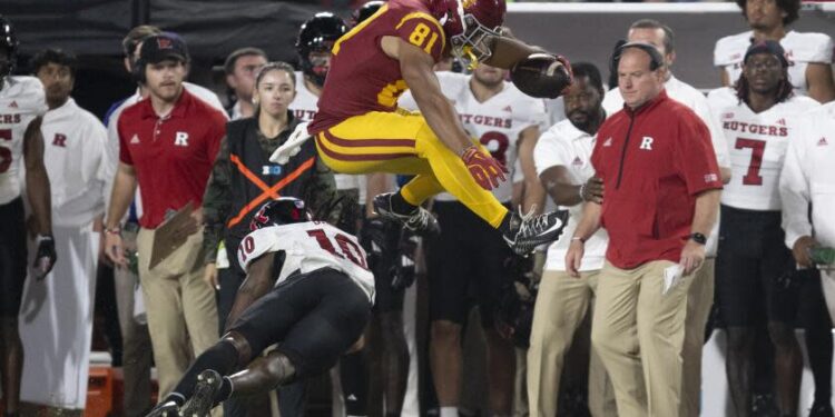 USC receiver Kyle Ford leaps over Rutgers defensive back Flip Dixon during the Trojans' win Friday night at the Coliseum